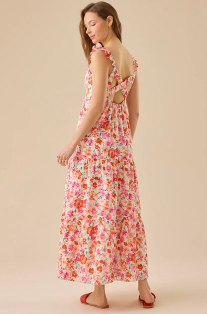 Woman wearing a floral dress with cut-out back on a beige background